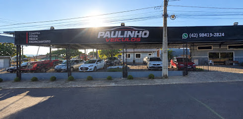 Fachada da Paulinho Veículos em Ivaí, PR, com veículos expostos no pátio coberto